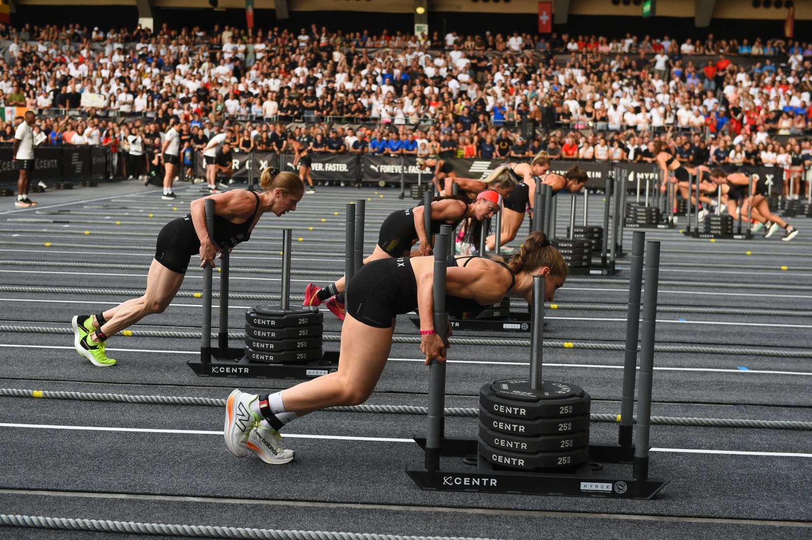 Two athletes pushing weighted sleds